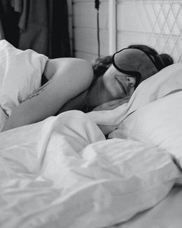 Femme S'allonge sur Un Lit Portant Un Masque de Nuit (Blog Pourquoi un masque)